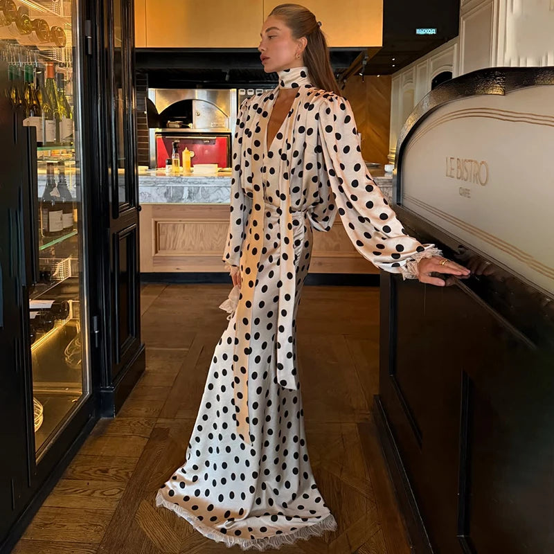 Woman in a polka dot satin puff sleeve blouse and maxi skirt set inside a restaurant