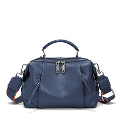 Blue handbag with multiple zippers on a white background