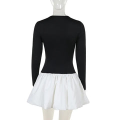 Black long-sleeve leotard with a white skirt on a mannequin against a white background