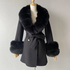 Black coat with fur trim on a mannequin against a plain background