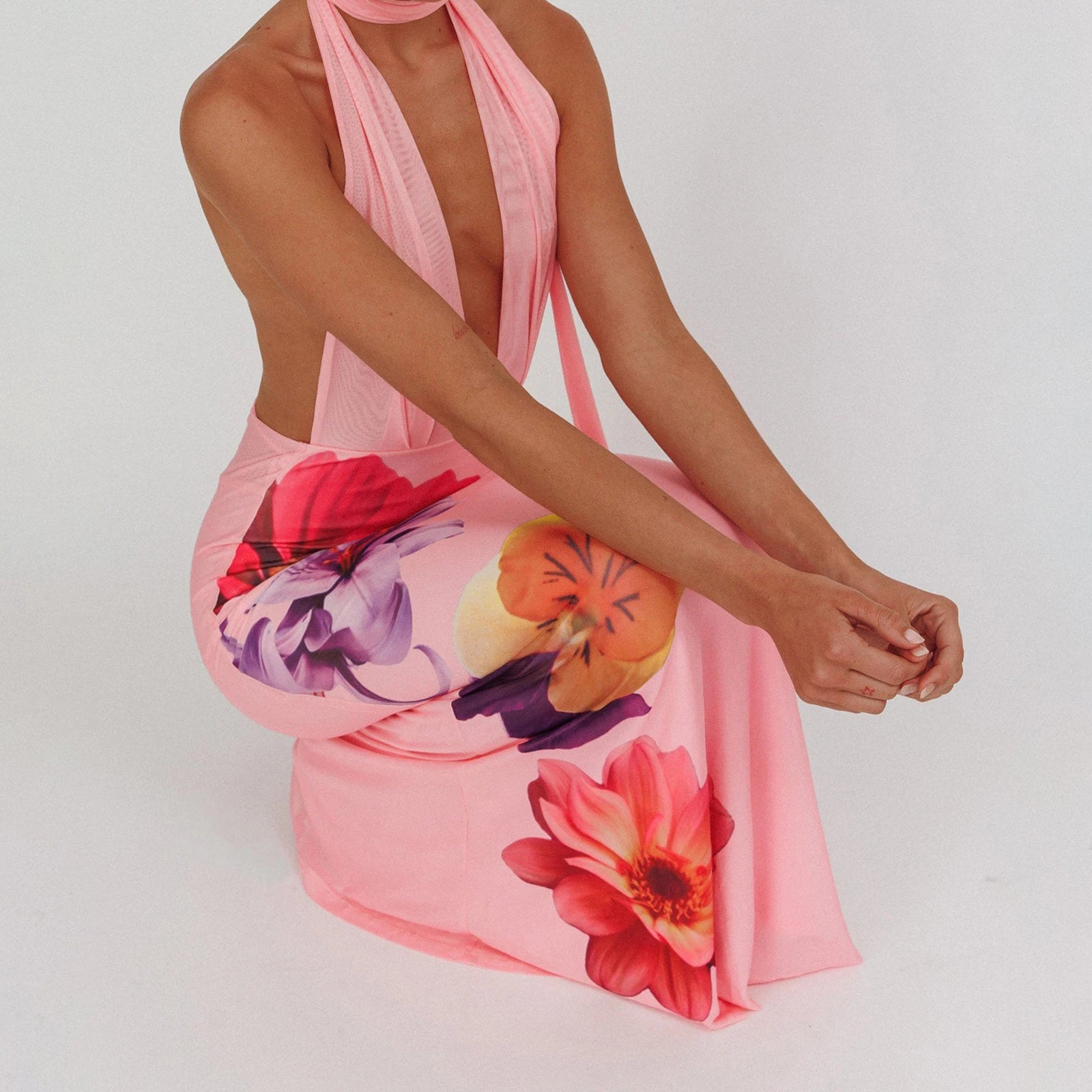 Woman wearing a pink floral dress on a white background