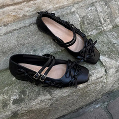 Black square toe flats with double buckle straps and bow details