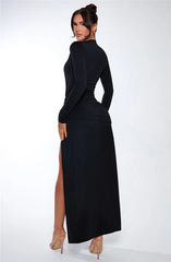 Woman wearing a black dress with a high slit
