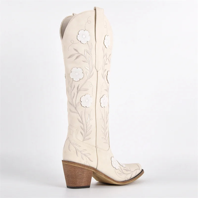 White cowboy boots with floral embroidery on a white background