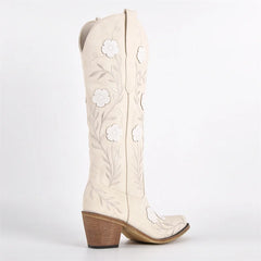 White cowboy boots with floral embroidery on a white background