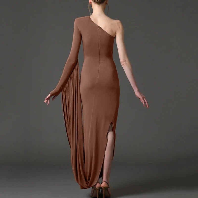 Woman wearing a brown one-shoulder dress with a slit on a gray background