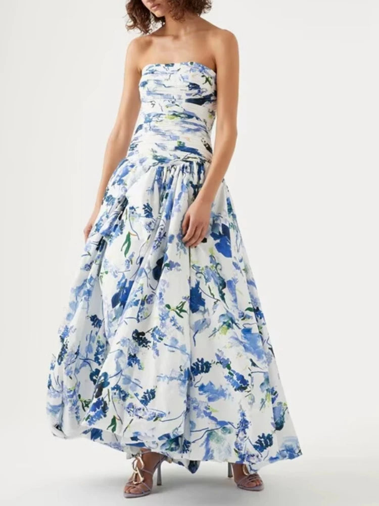 Woman wearing a strapless floral dress with blue and green flowers on a white background