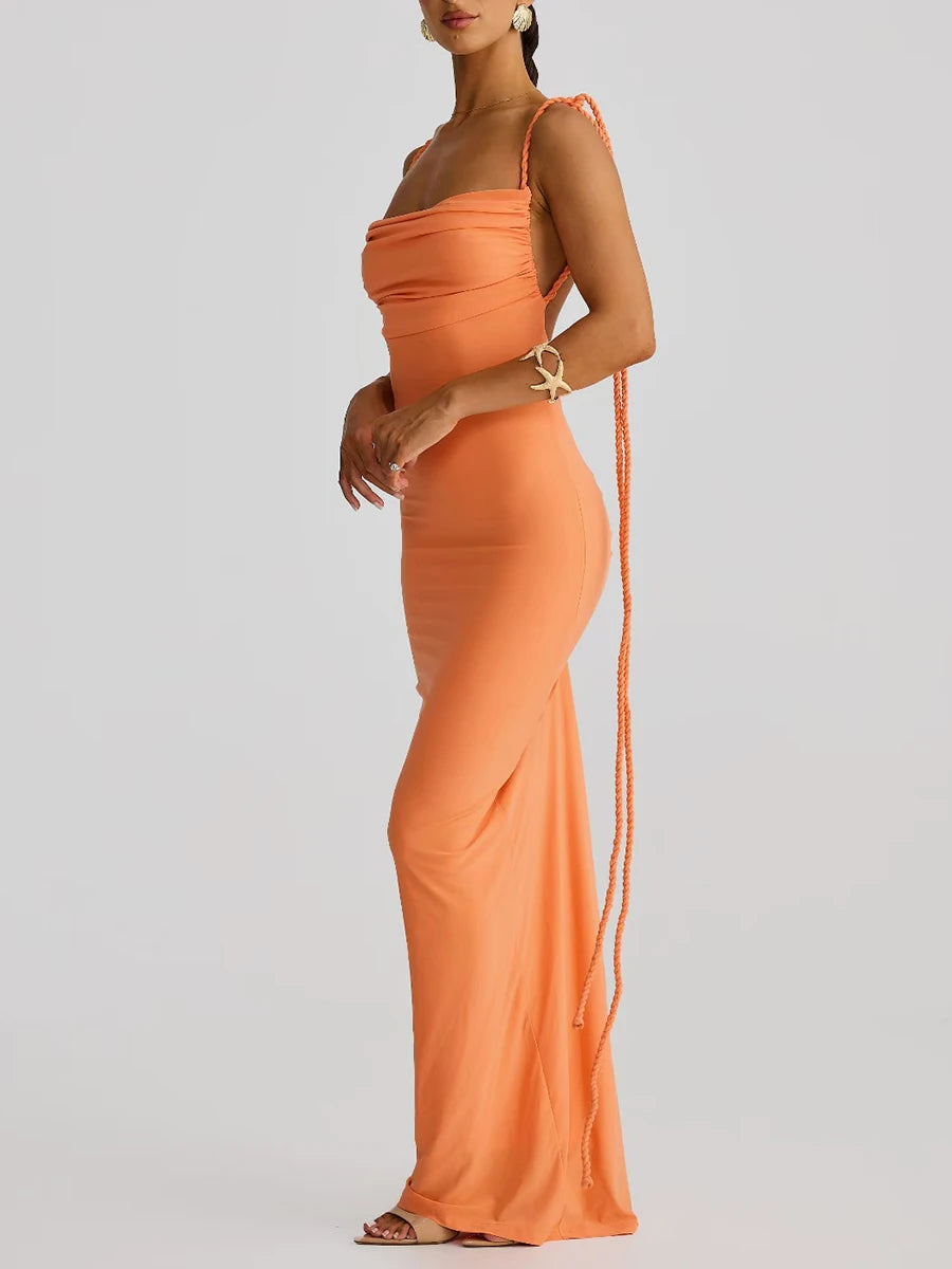Orange evening gown with a long train on a plain background
