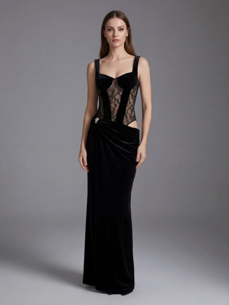Woman wearing a black evening gown with lace detailing on a gray background
