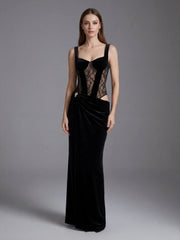 Woman wearing a black evening gown with lace detailing on a gray background