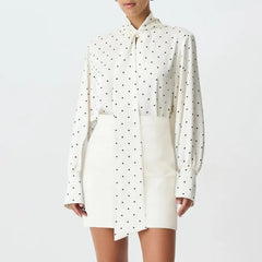White shirt dress with black polka dots on a white background