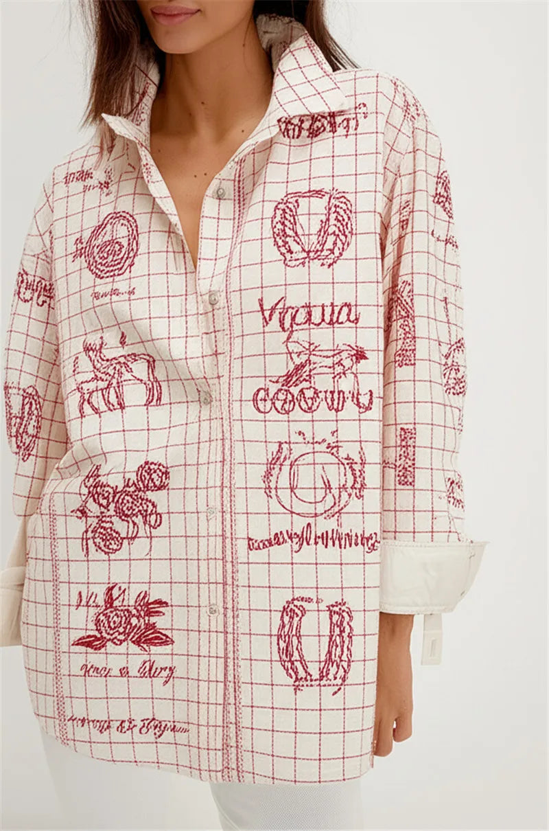 Person wearing a white shirt with red graphic designs on a plain background