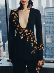 Black suit with gold floral embroidery against a cityscape background