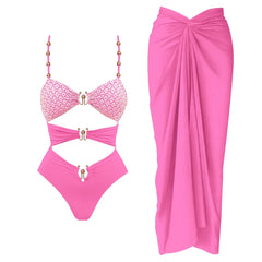 Pink cutout one-piece swimsuit with embellished straps and matching draped cover-up skirt.