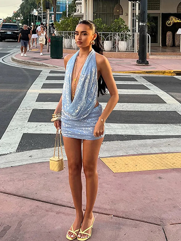 Woman in a blue dress standing on a city street corner