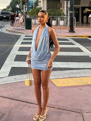 Woman in a blue dress standing on a city street corner