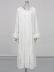 White dress with embellishments on a mannequin against a gray background