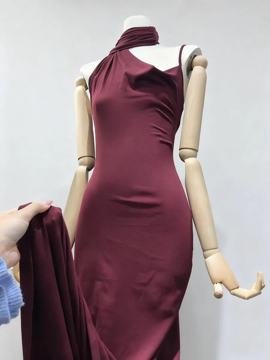 Wine red dress on a mannequin against a plain background