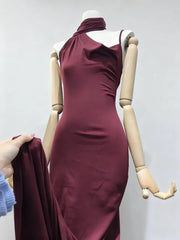 Wine red dress on a mannequin against a plain background