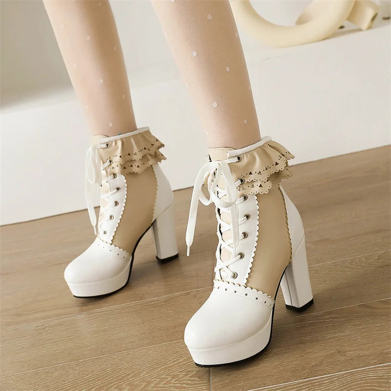 White high-heeled platform boots with lace details on a wooden floor.
