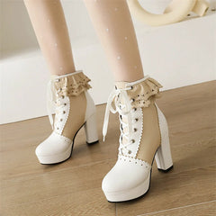 White high-heeled platform boots with lace details on a wooden floor.