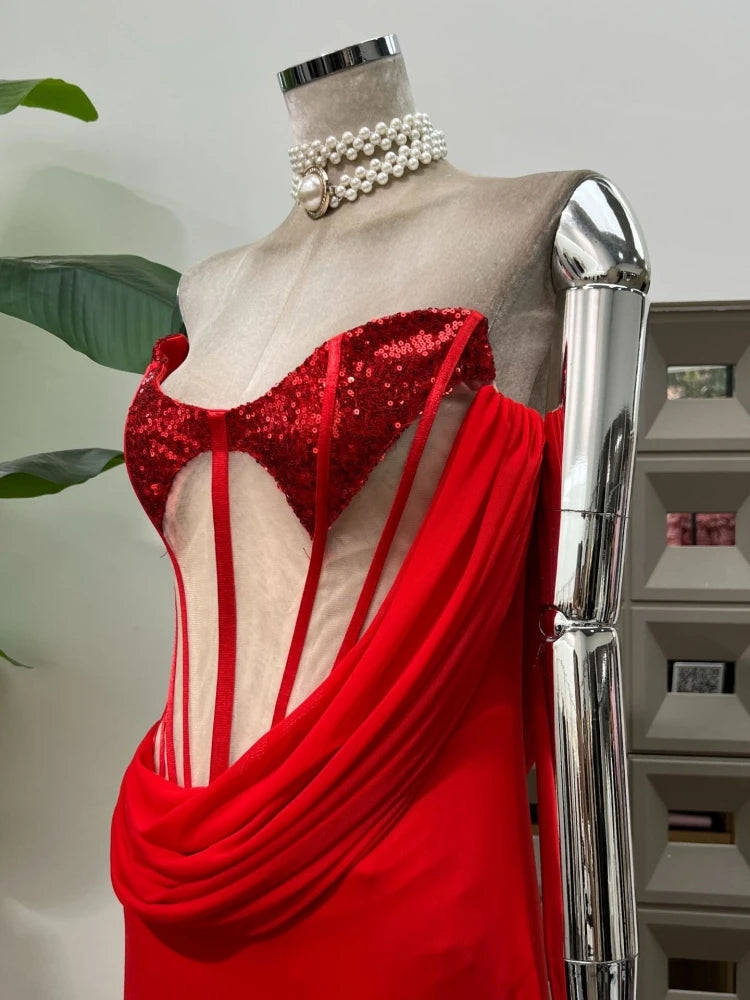 Red sequined dress on a mannequin with a silver arm in an indoor setting