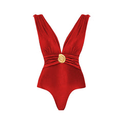 Close-up of a red textured one-piece swimsuit featuring a plunging neckline and gold-tone seashell embellishment at the waist.