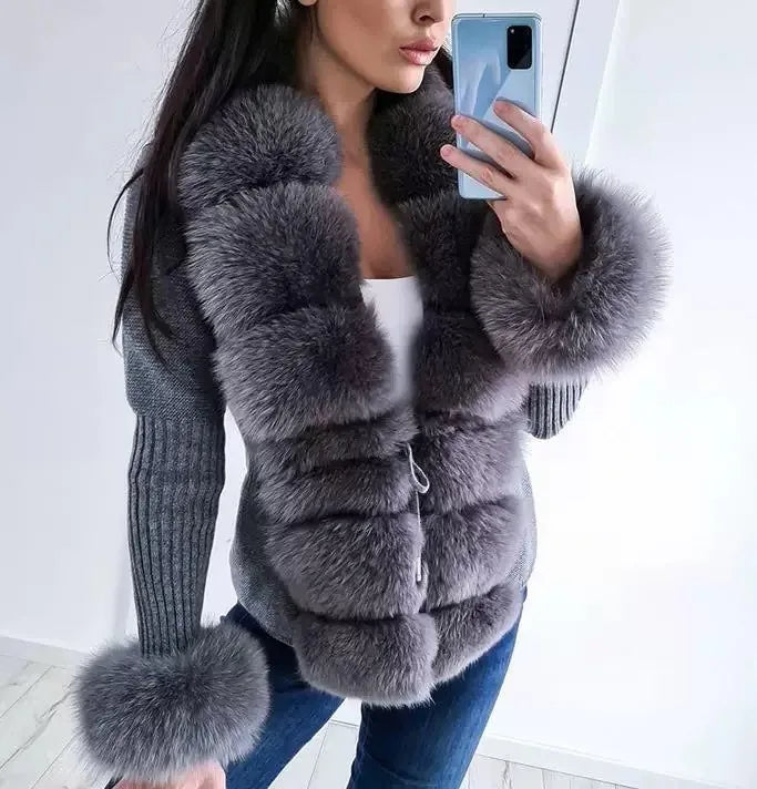 Person wearing a gray fur coat taking a mirror selfie.