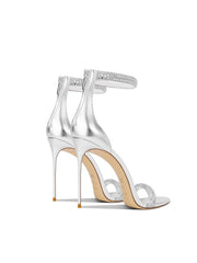 Silver high-heeled sandals with clear straps on a white background