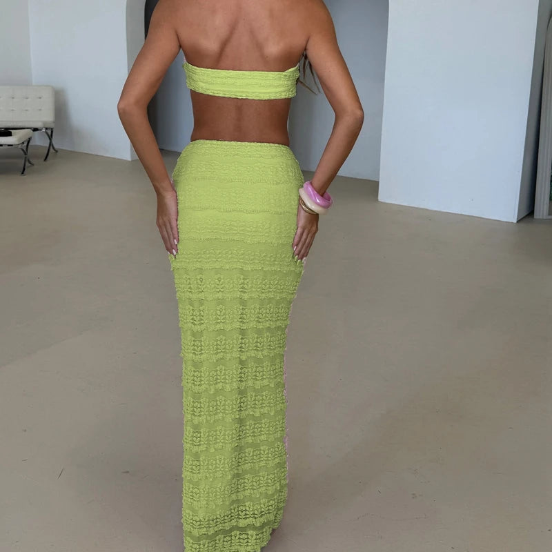 Person wearing a bright green strapless top and long skirt in an indoor setting.