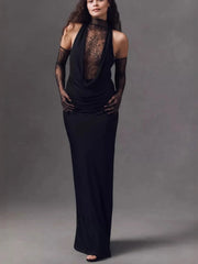 Woman wearing a black evening gown with sheer sleeves against a gray background