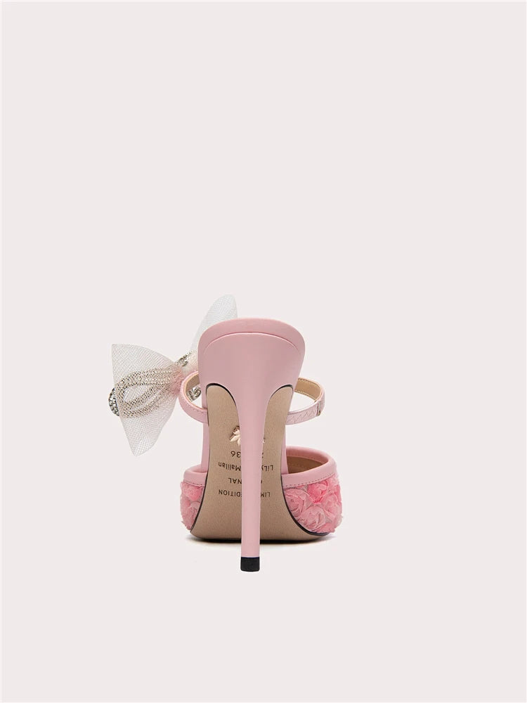 Pink high-heeled shoe with a bow on a white background
