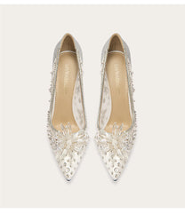 Pair of silver embellished shoes on a white background