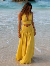 Halter V-neck crop top with a flowing maxi skirt on a beach.