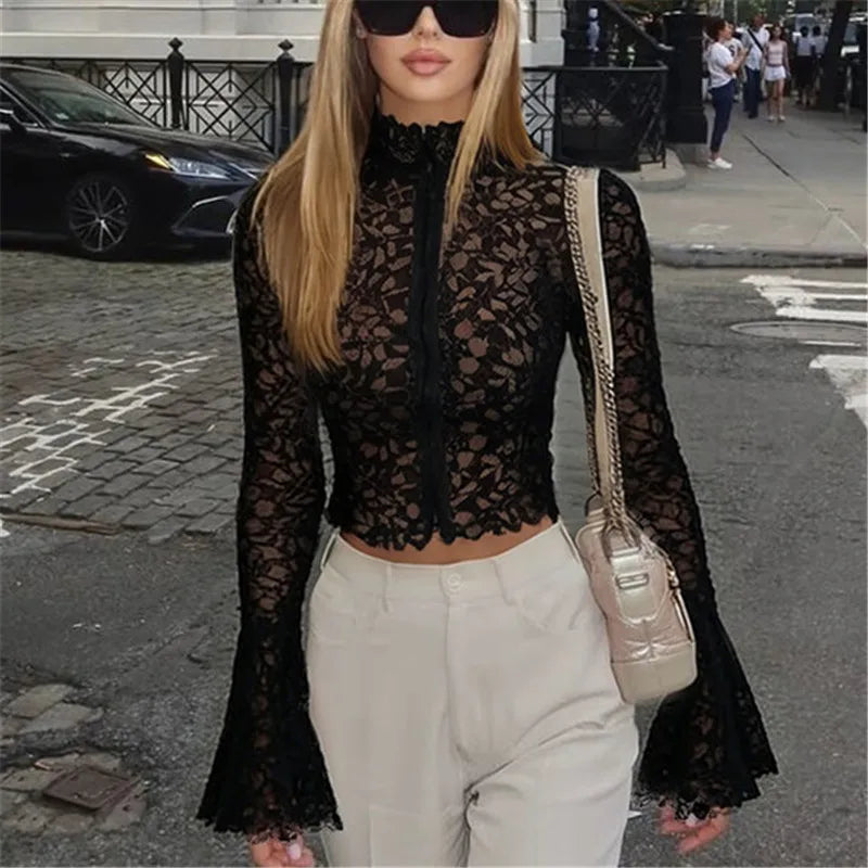 Sheer black lace high neck flare sleeve top worn on a city street