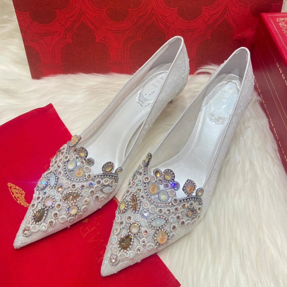 Silver embellished shoes on a red fabric background