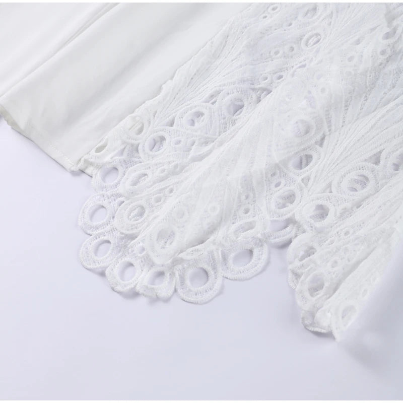 White fabric with intricate lace detailing on a light gray background