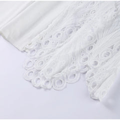 White fabric with intricate lace detailing on a light gray background