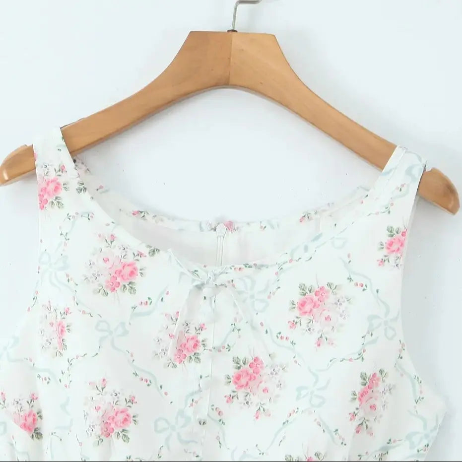 Floral-patterned dress on a wooden hanger against a white background