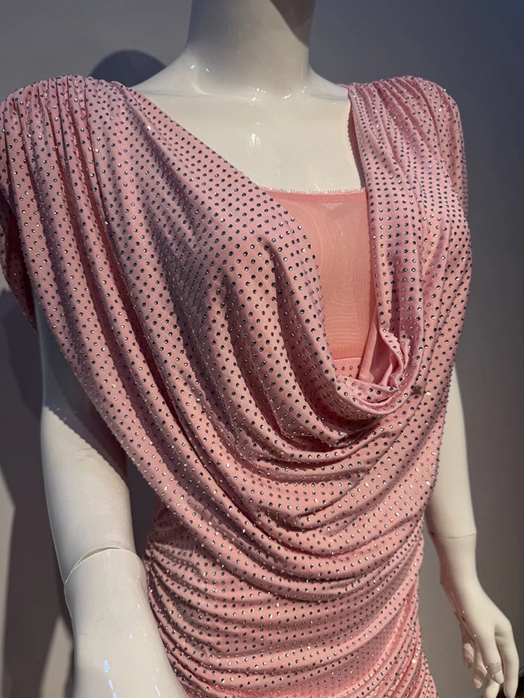 Mannequin wearing a pink dress with a draped design on a plain background
