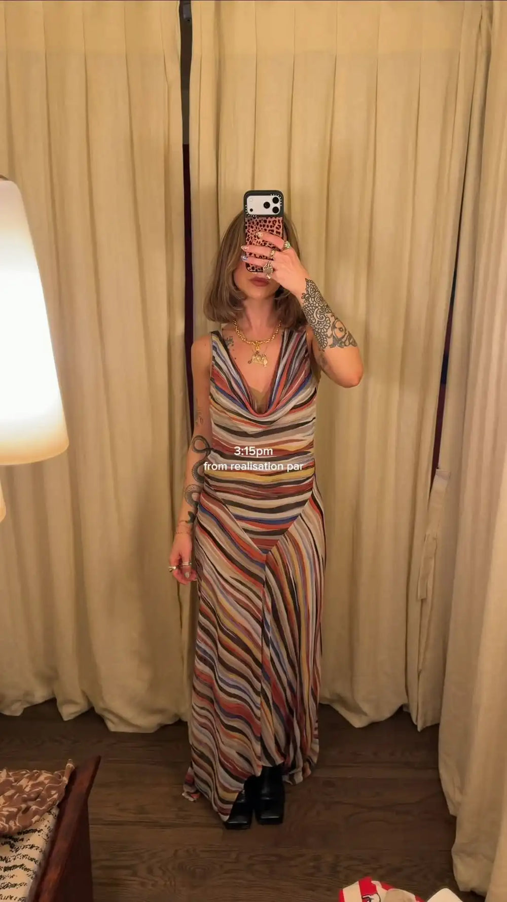 Woman in a striped V-neck maxi dress holding phone