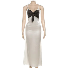 Mannequin wearing a white evening gown with a black bow on a white background