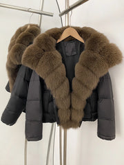 Black puffer jacket with brown fur collar on a hanger against a white background