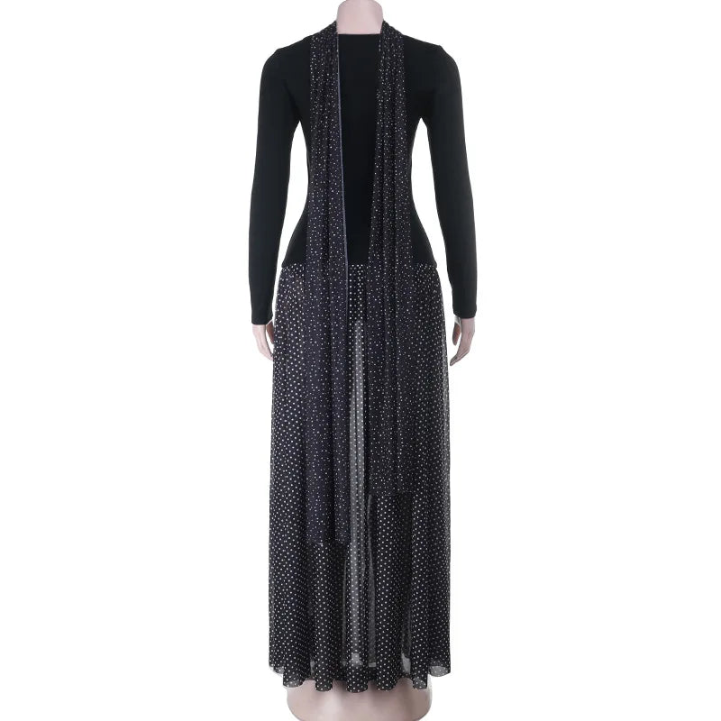 Black dress with a long, sheer, polka-dotted overlay on a white background