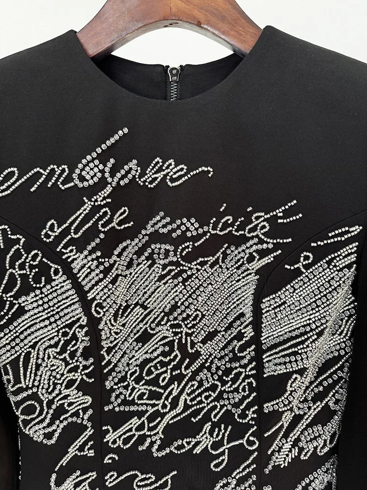 Detail of beaded script embellishment on mini dress neckline