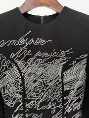 Detail of beaded script embellishment on mini dress neckline