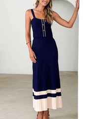 Woman wearing a navy blue and beige dress against a white background