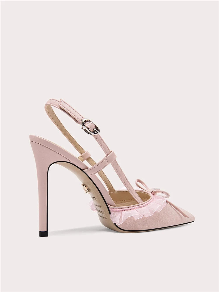 Pink high-heeled shoe with ruffled details on a light gray background