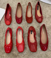 Close-up of red ballet flats showcasing the bow and microfiber texture.