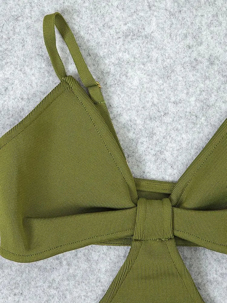 Green bikini top with a bow on a textured gray background